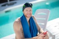 Smiling bearded man in swimming cap with smartphone Royalty Free Stock Photo