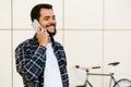 Smiling bearded man talking on smartphone, standing outdoors Royalty Free Stock Photo