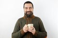Bearded man with wool sweater on white background holds in his hands a cup of hot tea Royalty Free Stock Photo