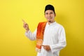 Smiling bearded Young Asian muslim man pointing the copy space to presenting something Royalty Free Stock Photo