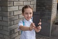 Smiling beatiful preteen girl taking a selfie outdoors. Child taking a self portrait with mobile phone. technology Royalty Free Stock Photo