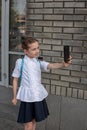 Smiling beatiful preteen girl taking a selfie outdoors. Child taking a self portrait with mobile phone. technology Royalty Free Stock Photo