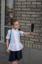 Smiling beatiful preteen girl taking a selfie outdoors. Child taking a self portrait with mobile phone. technology Royalty Free Stock Photo