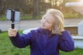 Smiling beatiful preteen girl taking a selfie outdoors. Child taking a self portrait with mobile phone. Royalty Free Stock Photo