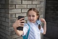 Smiling beatiful preteen girl taking a selfie outdoors. Child taking a self portrait with mobile phone. technology Royalty Free Stock Photo