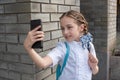 Smiling beatiful preteen girl taking a selfie outdoors. Child taking a self portrait with mobile phone. technology Royalty Free Stock Photo