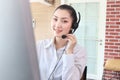 Smiling beautiful Asian woman with headphones work at call center service desk consultant, call center agent with headset talk Royalty Free Stock Photo