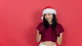 Smiling beautiful asian woman with santa hat giving a thumbs up gesture of approval and success with a beaming smile Royalty Free Stock Photo