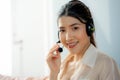 Smiling beautiful Asian woman working in call center with international team as telemarketing customer service agents. Headset Royalty Free Stock Photo