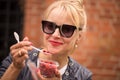 Smiling beautiful blond woman eating strawberries Royalty Free Stock Photo