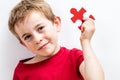 Smiling beautiful boy with freckles finding jigsaw for unique solution Royalty Free Stock Photo