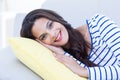 Smiling beautiful brunette relaxing on the couch and looking at camera Royalty Free Stock Photo