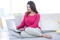 Smiling beautiful brunette using her laptop on the couch Royalty Free Stock Photo