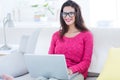 Smiling beautiful brunette using her laptop on the couch Royalty Free Stock Photo