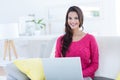 Smiling beautiful brunette using her laptop on the couch Royalty Free Stock Photo