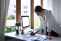 Beautiful businesswoman standing and working at her office desk. Royalty Free Stock Photo