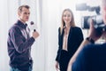 Smiling beautiful businesswoman in suit giving interview to journalist and looking at camera Royalty Free Stock Photo