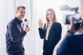 Smiling beautiful businesswoman in suit giving interview to journalist and waving hand Royalty Free Stock Photo