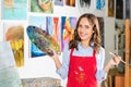 smiling beautiful female artist holding painting brush and palette Royalty Free Stock Photo