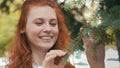 Smiling beautiful ginger girl in green park