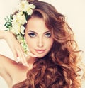 Smiling Beautiful girl.Delicate pastel flowers in curly hair