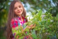 Smiling beautiful girl farmer take care of green citrus plants in the garden. Farming concept Royalty Free Stock Photo