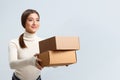 Smiling beautiful girl hands over boxes with orders. Young woman with purchases. delivery Royalty Free Stock Photo