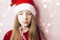 Smiling beautiful girl with long hair in fluffy Santa Claus hat on a pink background Royalty Free Stock Photo