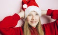 Smiling beautiful girl with long hair in fluffy Santa Claus hat on a pink background. Royalty Free Stock Photo