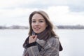 Smiling beautiful girl in a park in a fashionable coat. Checkered autumn coat