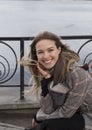 Smiling beautiful girl in a park in a fashionable coat. Checkered autumn coat