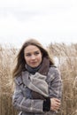 Smiling beautiful girl in a park in a fashionable coat. Checkered autumn coat