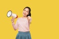 Smiling beautiful girl pointing at camera and holding megaphone Royalty Free Stock Photo