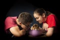 A smiling beautiful girl presents a beagle puppy to a young man in a purple gift box for Christmas or a birthday Royalty Free Stock Photo