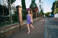 Smiling beautiful girl runs with shoes in her hands along the old street Royalty Free Stock Photo