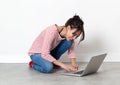 Smiling beautiful girl sitting on the floor, working on computer Royalty Free Stock Photo