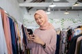 smiling a beautiful girl wearing a hijab holding a smartphone Royalty Free Stock Photo