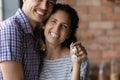 Smiling beautiful hispanic family couple holding keys. Royalty Free Stock Photo