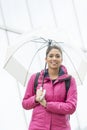 Smiling beautiful latin woman with umbrella in the street.