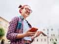 Smiling beautiful modern young female teenager Portrait with extraordinary hairstyle in checkered shirt holding a slim smartphone