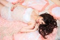 Smiling beautiful pregnant brunette girl in soft peach pillows Royalty Free Stock Photo