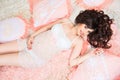 Smiling beautiful pregnant brunette girl in soft peach pillows Royalty Free Stock Photo