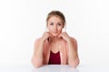 Smiling beautiful 20s blond woman sitting at sparse desk Royalty Free Stock Photo