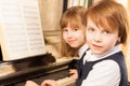 Smiling beautiful small girls playing piano Royalty Free Stock Photo