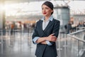 Beautiful stewardess with arms crossed looking away in airport terminal Royalty Free Stock Photo