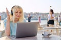 Smiling beautiful teenage girl in headphones looking into laptop Royalty Free Stock Photo