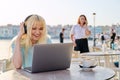 Smiling beautiful teenage girl in headphones looking into laptop Royalty Free Stock Photo