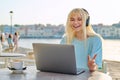 Smiling beautiful teenage girl in headphones looking into a laptop. Royalty Free Stock Photo