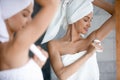 Smiling beautiful woman applying antiperspirant to armpit in bathroom Royalty Free Stock Photo