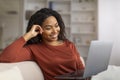 Smiling Beautiful Woman Browsing Internet On Her Laptop While Relaxing At Home Royalty Free Stock Photo